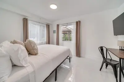 a bedroom with a bed and a desk and a window at Wynwood Charm, at the Heart of the Art! in Miami