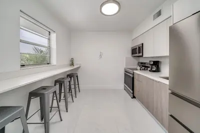 a kitchen with a counter and stools in it at Wynwood Charm, at the Heart of the Art! in Miami
