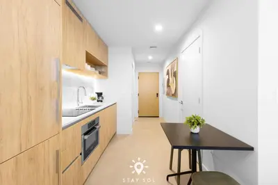 a kitchen with wooden cabinets and a black table at Downtown Retreat Pools Spa & Lounges Miami in Miami