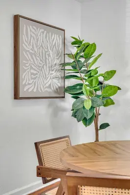 a dining room table with a plant on the wall at Victoria Park Oasis Walk to las Olas Beach in Fort Lauderdale