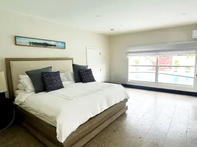 a bedroom with a large bed and a window at Luxury 4BR Coconut Grove Home wIith Pool and BBQ in Miami