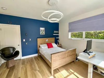 a bedroom with blue walls and a bed with a desk at Luxury 4BR Coconut Grove Home wIith Pool and BBQ in Miami