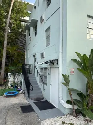 a white building with a staircase leading to a door at 9064 Collins Ave 2 in Miami Beach