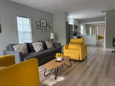 a living room with a couch and a table and yellow chairs at Hollywood Escape in Hollywood