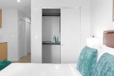 a bedroom with a white bed with a green pillow at Sophisticated Studio with Pools in Miami