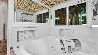 a white bathroom with a sink and two windows at Casa Pineapple Social by AvantStay Spa Game Room EV Charger Near Las Olas Fort Lauderdale Beaches Sleeps 16 in Fort Lauderdale