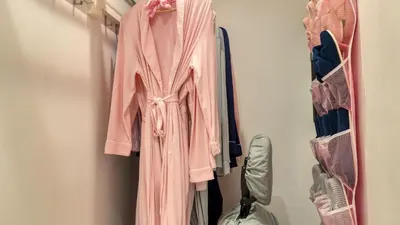 a pink robe hanging on a rack in a closet at Casa Pineapple Social by AvantStay Spa Game Room EV Charger Near Las Olas Fort Lauderdale Beaches Sleeps 16 in Fort Lauderdale