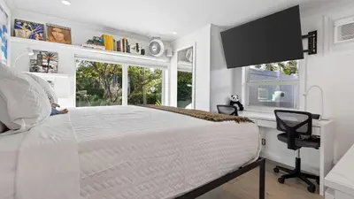 a white bedroom with a large bed and a window at Casa Pineapple Social by AvantStay Spa Game Room EV Charger Near Las Olas Fort Lauderdale Beaches Sleeps 16 in Fort Lauderdale