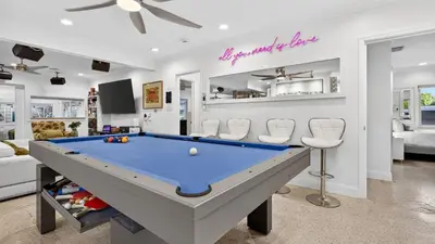 a living room with a pool table in it at Casa Pineapple Social by AvantStay Spa Game Room EV Charger Near Las Olas Fort Lauderdale Beaches Sleeps 16 in Fort Lauderdale