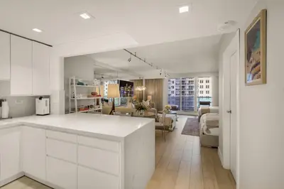 a kitchen with white cabinets and a living room at Seaside Condo - Studio for 4 in Miami Beach