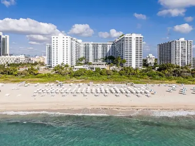 an aerial view of a beach with white chairs and buildings at Seaside Condo - Studio for 4 in Miami Beach
