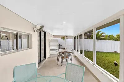 a porch with chairs and a table with a view of a yard at Waterfront Modern Hollywood Hard Rock airport in Fort Lauderdale