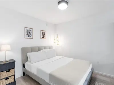 a white bedroom with a large bed and a nightstand at Modern Studio by Bayside & Cruise Port in Miami