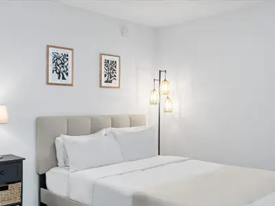 a white bedroom with a bed and two pictures on the wall at Modern Studio by Bayside & Cruise Port in Miami