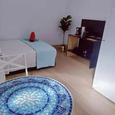a room with a bed and a table and a rug at Quiet Studio Retreat attached to big House in Miami