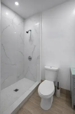 a white bathroom with a toilet and a shower at Quiet Studio Retreat attached to big House in Miami