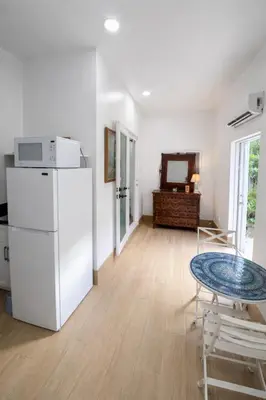 a living room with a white refrigerator and a table at Quiet Studio Retreat attached to big House in Miami