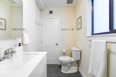 a white bathroom with a toilet and a sink at Modern Apartment in Prime Miami Location in Miami