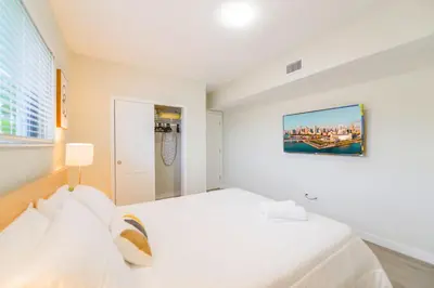 a white bedroom with a white bed and a window at Modern Apartment in Prime Miami Location in Miami
