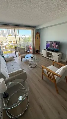 a living room with a couch and tables and a tv at Canal-front two-bedroom condo near Sunny Isles in North Miami Beach