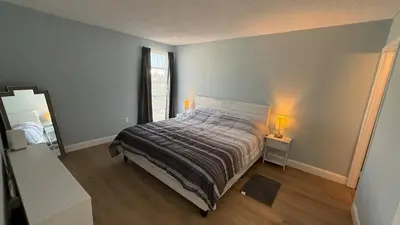 a bedroom with a bed and a mirror and a window at Canal-front two-bedroom condo near Sunny Isles in North Miami Beach