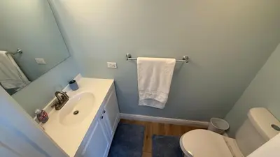 a bathroom with a sink and a toilet and a mirror at Canal-front two-bedroom condo near Sunny Isles in North Miami Beach