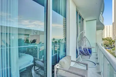 a balcony with a chair and a window at Cozy Apartment -Balcony & Beachfront Resort in Hollywood