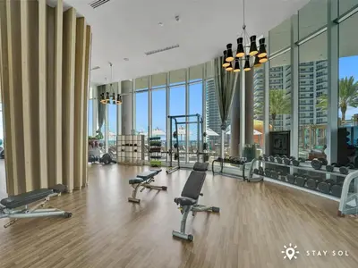 a gym with exercise equipment in a building with windows at Cozy Apartment -Balcony & Beachfront Resort in Hollywood