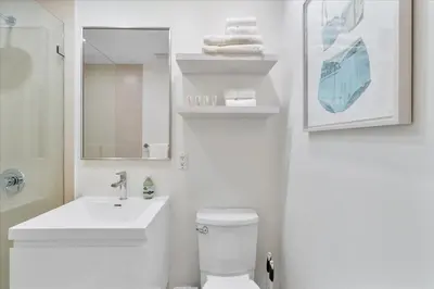 a bathroom with a toilet and a sink and a mirror at Cozy Miami Beach Apartment walking distance to Beach and Ocean in Miami Beach