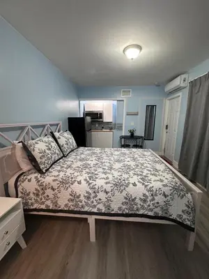 a bedroom with a large bed with a floral bedspread at Cozy room close to everything, 5min to the airport in Miami