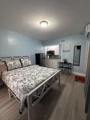 a bedroom with a bed in a room with a kitchen at Cozy room close to everything, 5min to the airport in Miami