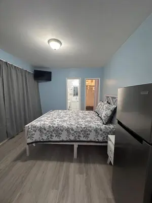 a bedroom with a bed and a refrigerator in it at Cozy room close to everything, 5min to the airport in Miami