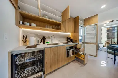 a kitchen with wooden cabinets and a dishwasher at Modern and Cozy 1BD Apt with Gym & Pool in Miami