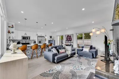 a living room with a couch and a kitchen at Cozy house with a pool in Miami in Miami
