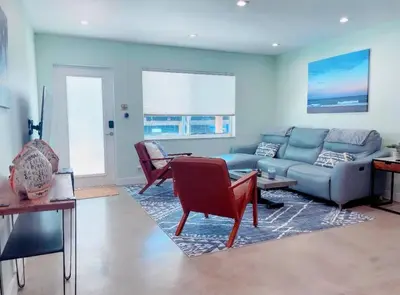 a living room with a couch and a table and chairs at Las Tortugas Modern Oasis Getaway Many Amenities in Fort Lauderdale