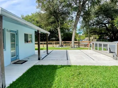 a small blue building with a patio and grass at Las Tortugas Modern Oasis Getaway Many Amenities in Fort Lauderdale