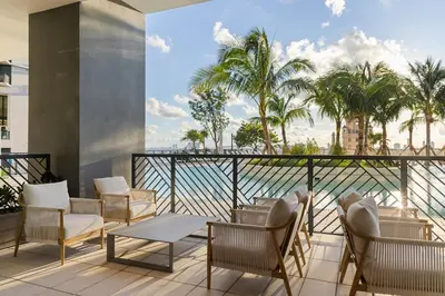 a balcony with chairs and tables and palm trees at 2909 Elegant 1BR in Miami Downtown with Pool and Gym in Miami