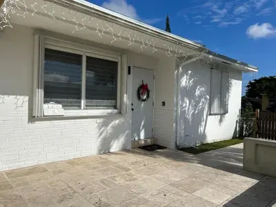 a white house with a door and a window at Florida Cozy Home!!! in Hallandale Beach