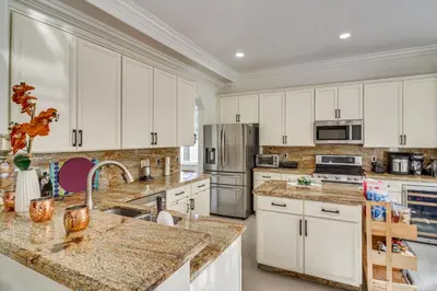a kitchen with white cabinets and granite counter tops at Great for Gatherings! Sleek and Relaxing Hialeah Gem in Hialeah