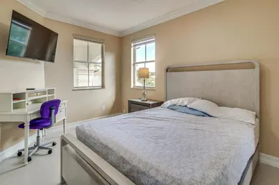 a bedroom with a bed and a desk and a computer at Great for Gatherings! Sleek and Relaxing Hialeah Gem in Hialeah