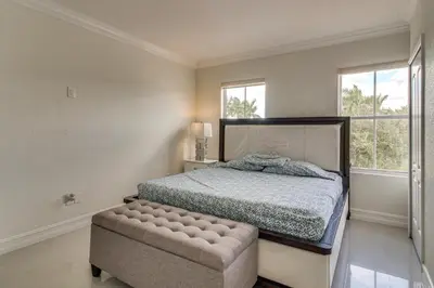 a bedroom with a bed and a large window at Great for Gatherings! Sleek and Relaxing Hialeah Gem in Hialeah