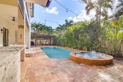 a swimming pool with a fountain in a yard at Great for Gatherings! Sleek and Relaxing Hialeah Gem in Hialeah