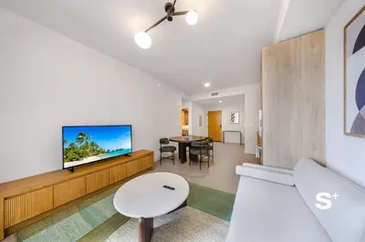 a living room with a couch and a tv and a table at Spacious & Elegant 1BD Apt in Miami in Miami