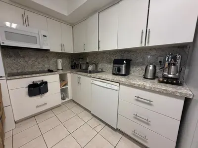 a kitchen with white cabinets and white appliances at Beautiful Apartment in Sunny Isles Beach in Sunny Isles Beach