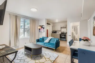 a living room with a blue couch and a table at Lauderdale Breeze Villas in Fort Lauderdale