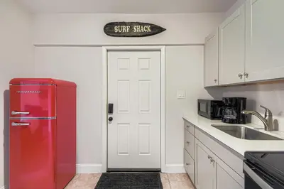 a red refrigerator in a kitchen with a sink at Lauderdale Breeze Villas in Fort Lauderdale
