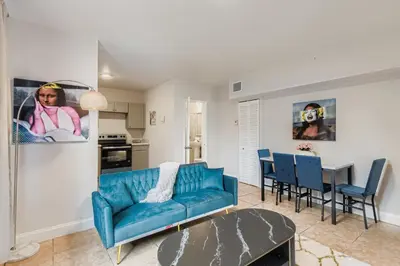 a living room with a blue couch and a table at Lauderdale Breeze Villas in Fort Lauderdale