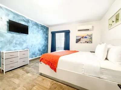 a white bedroom with a bed and a tv at Casa Pellegrino Boutique Hotel in Hollywood