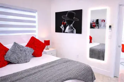 a bedroom with a woman with a hat on a cell phone at Villa Clara EPIC-Little Havana in Miami