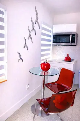 a kitchen with a table and two chairs and birds on the wall at Villa Clara EPIC-Little Havana in Miami